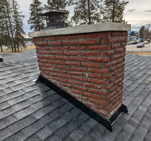 A rooftop with a chimney after new flashing has been installed